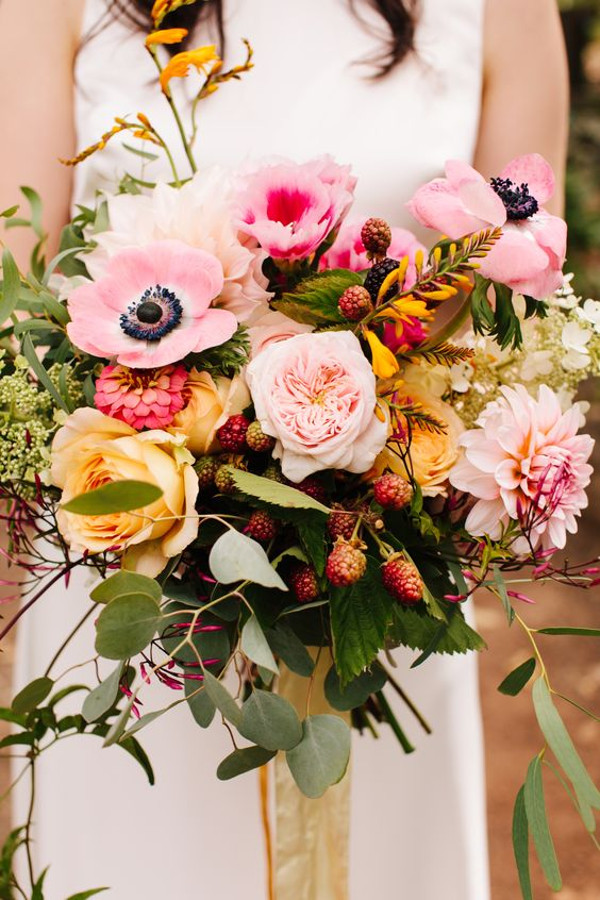 Wild wedding bouquet with light pink anemones, peach roses, light pink garden roses, pink lisianthus and light pink dahlias with eucalyptus and blackberries