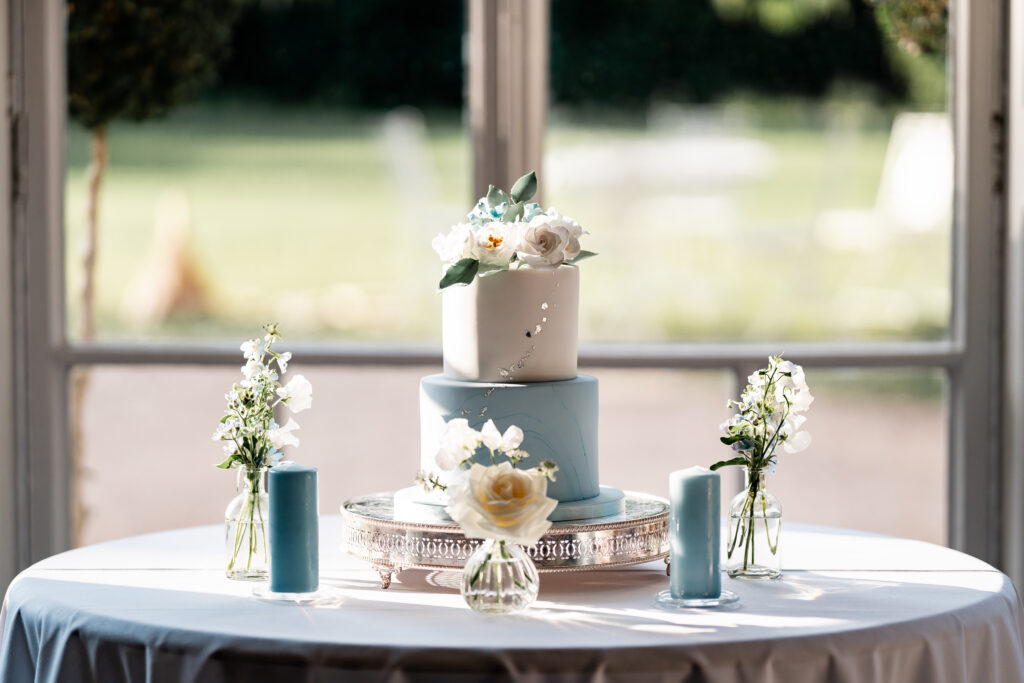 Two tier white and blue wedding cake silver details